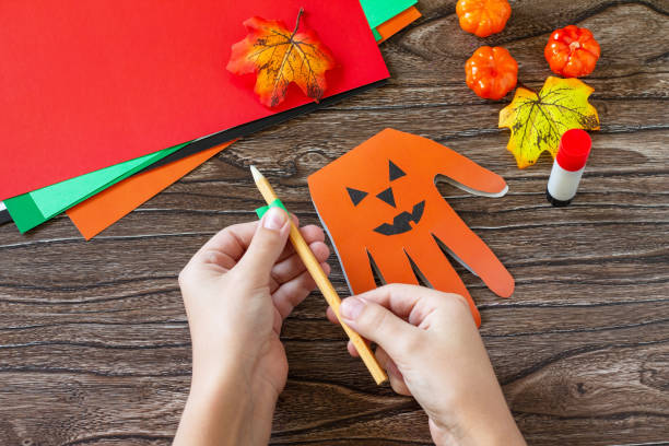 istock Instructions, step 4. Greeting card halloween on wooden table. Children's creativity project, crafts, crafts for kids. 1277812204