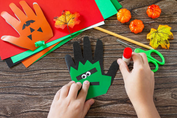 istock Instructions, step 9. Greeting card halloween on wooden table. Children's creativity project, crafts, crafts for kids. 1277812208