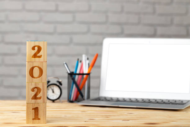 istock Wooden cubes 2021 Year on working table with open laptop 1277813128