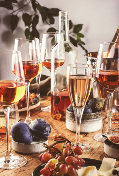 istock Rose wine glasses and bottles on table served for festive dinner party with different kinds of appetizers and fruits 1277813650