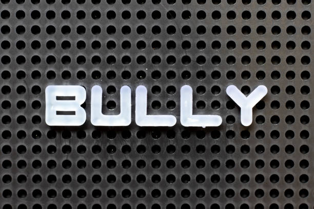 istock White color alphabet with word bully on black pegboard background 1277814048