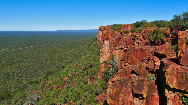 Panoramic view over Kalahari desert out to horizon from the ridge of red colored rocks of Waterberg Plateau, Namibia, Africa. stock photo