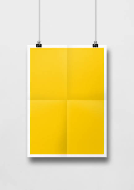 istock Yellow folded poster hanging on a white wall with clips 1277825060