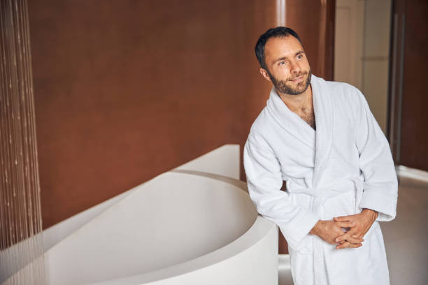 istock Handsome young man standing by bathtub at wellness center 1277827351