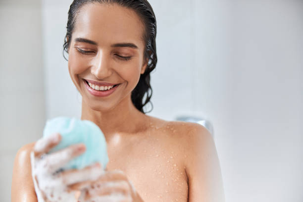 istock Joyful young woman holding bath loofah sponge 1277836586