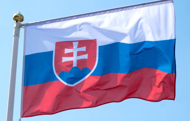 istock Slovak Republic flag waving in sunny blue sky. 1277837723