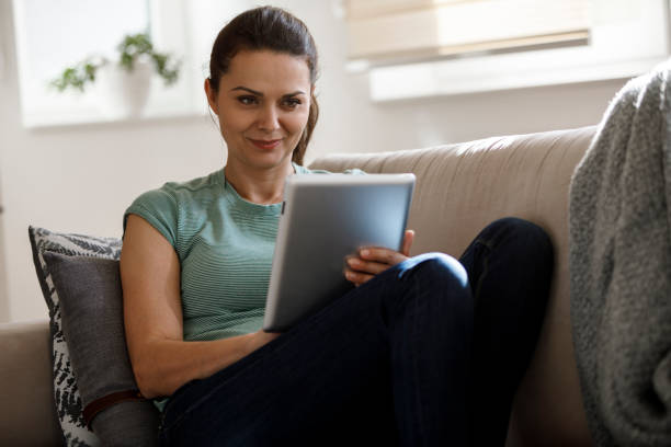 istock Smiling mature woman using digital tablet at home 1277837776