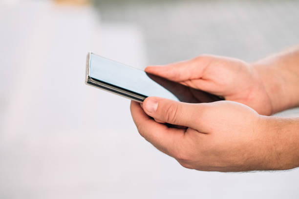 istock male hands holding a modern phone mock-up for your text message or information content, on a light blurred background 1277838299