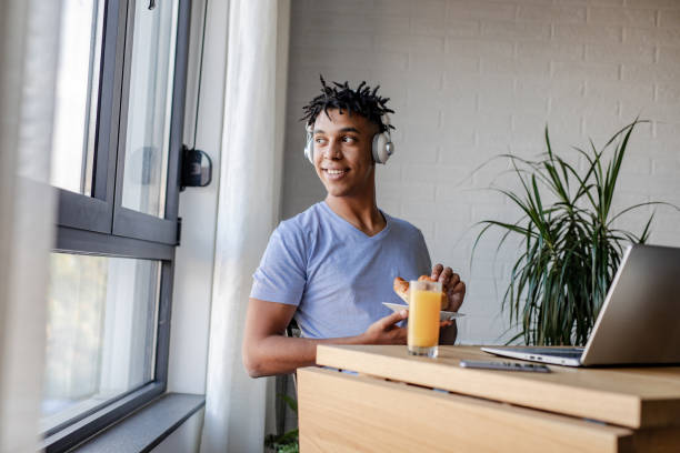 istock Young African American man eating breakfast and using laptop 1277838406