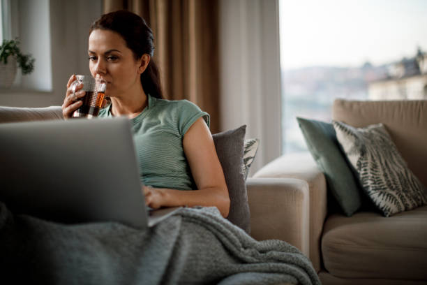 istock Mature woman drinking tea and using laptop at home 1277838957