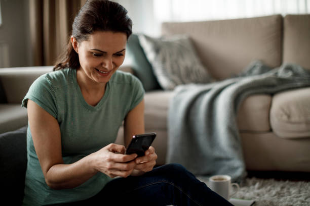 istock Mature woman using mobile phone at home 1277839535