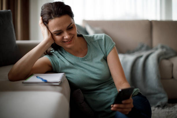 istock Smiling mature woman using mobile phone at home 1277839608
