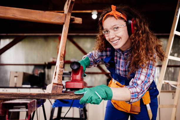 istock Young female carpenter working with grinding machine. 1277839645