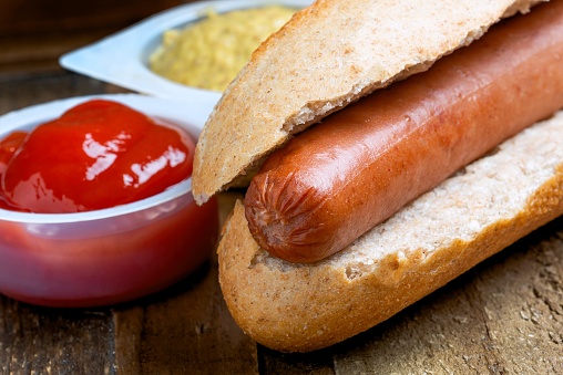 Hotdog with mustard and ketchup sauce on the side