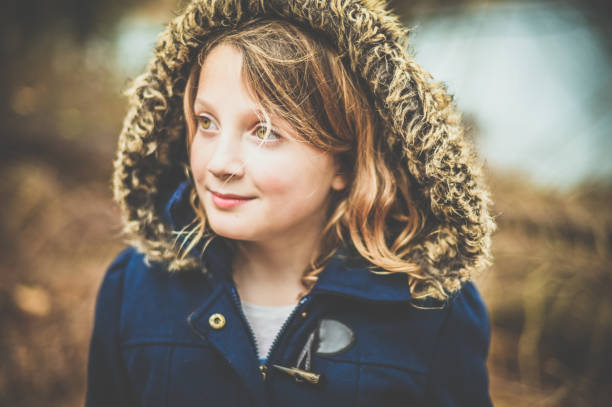 Pretty little child outdoors in winter Adorable little girl in a fur trimmed winter jacket outdoors kids winter coat stock pictures, royalty-free photos & images