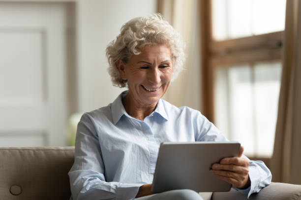 istock Happy old woman spending time at home with tablet computer 1277845359