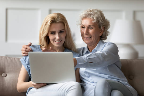istock Caring grown up daughter teaching elderly mother to use laptop 1277845376