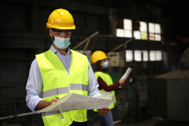 istock Factory workers work with face masks in the factory on a new project protecting themselves from the corona virus 1277858494