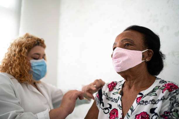 istock Nurse applying vaccine on patient's arm using face mask 1277861450