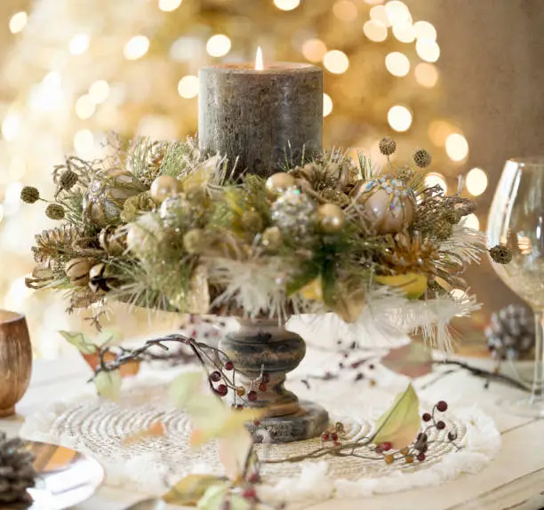 Elegant Holiday Candle in Rustic Gold against a Golden Lights Christmas Tree