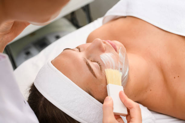 istock Beautician apply cosmetic mask on client face 1277864375