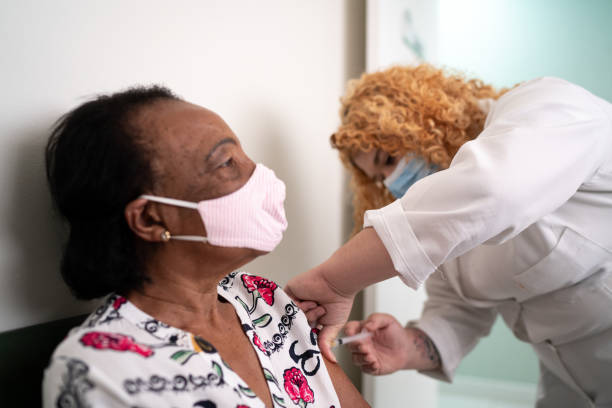 istock Nurse applying vaccine on patient's arm using face mask 1277866157