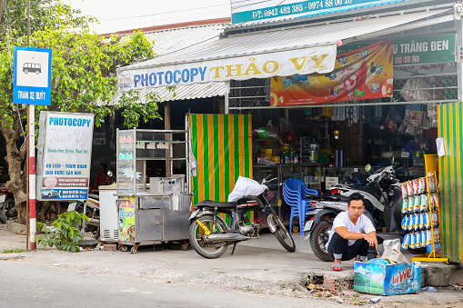 Mekong Delta, Vietnam - December 28, 2019: People in front of a storefront in a rural village in the Mekong Delta in Vietnam