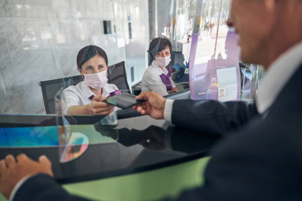 istock Cheerful women helping man at registration desk 1277872380