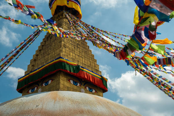 istock Multicolored Buddhist prayer flags with mantras on a background of blue sky and an ancient stupa. Traditional Tibetan and Nepalese threads with rectangular colored pieces of fabric 1277874520