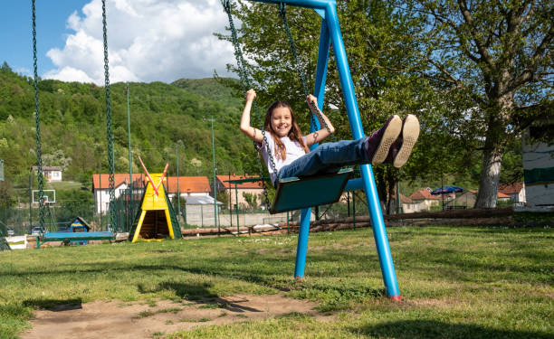 Cute small girl swinging outdoors