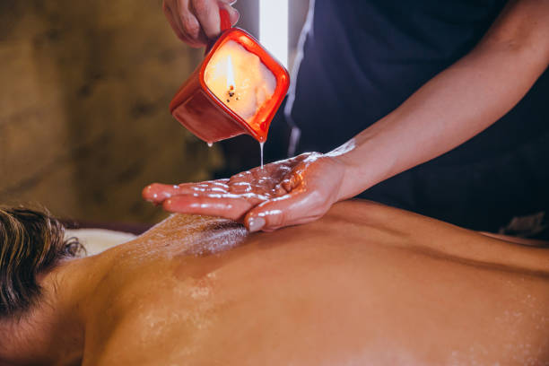 Candle massage. Woman at spa getting a body oil treatment candle with hot wax. candle wax stock pictures, royalty-free photos & images