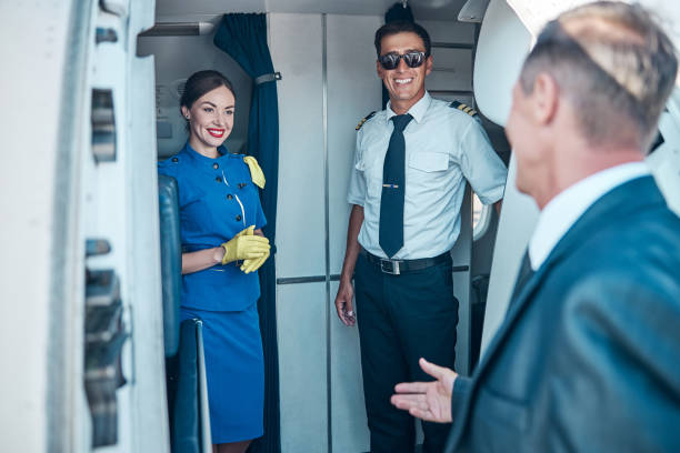 istock Smiling crew meeting businessman on passenger plane 1277876776
