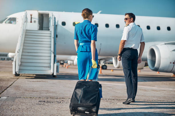 istock Cheerful crew walking with suitcase to plane 1277876819