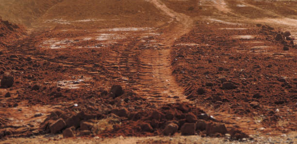 Red dusty sandy road - focus on the tire tracks Large stock image of a red sandy dusty road with tire tracks on it looking like the planet Mars. Selective focus on the center of the image and blurred edges single lane road footpath dirt road panoramic stock pictures, royalty-free photos & images