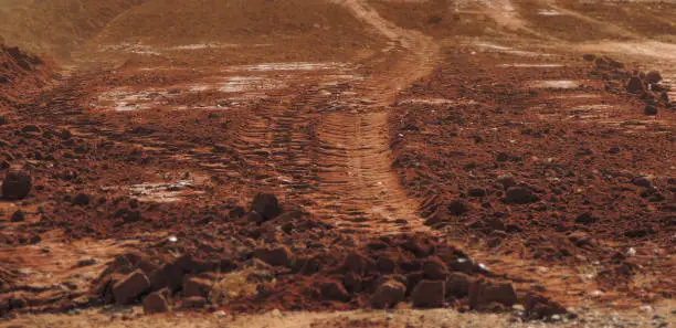 Photo of Red dusty sandy road - focus on the tire tracks