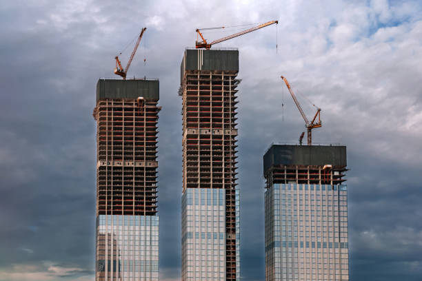 skyscrapers under construction, modern city buildings against dark stormy sky