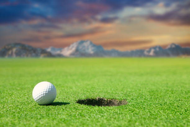 istock Golf Ball By Edge of Hole Sunset Composite 1277921486