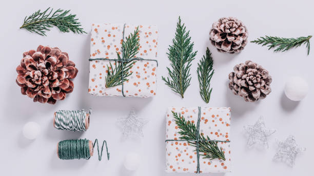 istock Wrapped presents with cedar and cones on white background. Preparation for Christmas holiday concept, top view 1277926472