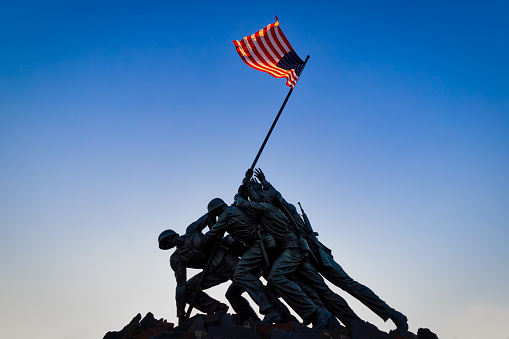 Arlington, Virginia / USA - September 29, 2018:  The sun sets on the US Marine Corps War Memorial designed by sculptor Felix de Weldon and architect Horace W. Peaslee which was unveiled on November 10, 1954.