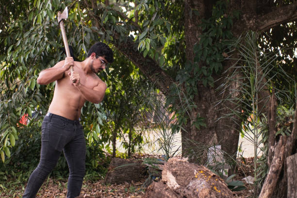 istock Young man using an axe to cut wood. 1277926620