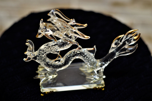 A decorative glass Chinese dragon on the desk