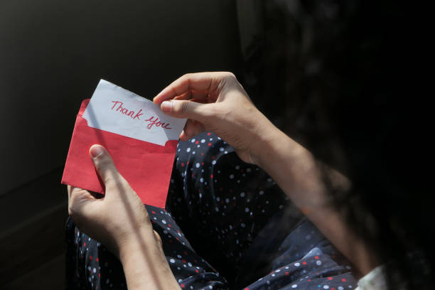 istock women's hand holding thank you note , top down 1277931610