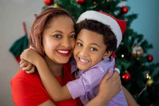 istock Happy mother and son hugging while celebrating Christmas together at home 1277934061