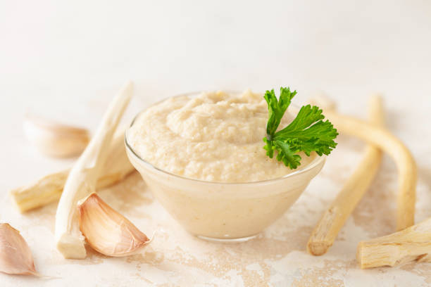 Horseradish sauce in a jar and ingredients on a white background.