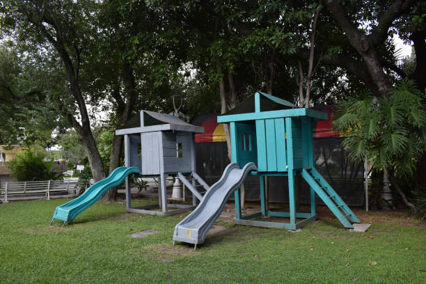 istock View of two slides in a public park, background grass and trees 1277941098