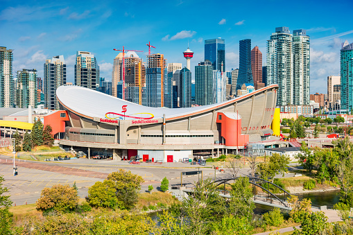 Skyline of Calgary Alberta Canada with the Scotiabank Saddledome arena in the foreground, on a sunny day.