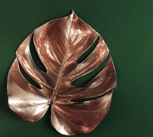 istock Gold monstera leaves frame on a green  background  top view.  copy space. abstract poster. 1277947803