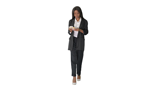 Wide shot. Front view. Happy African American woman counting money while walking on white background. Professional shot in 4K resolution. . You can use it e.g. in your medical, commercial video, business, presentation, broadcast