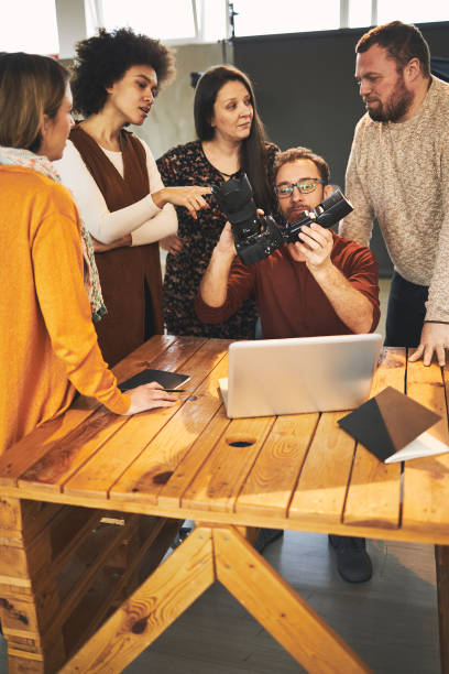 istock Small multicultural attendees standing in studio and carefully listening to their tutor talking about camera parts. 1277965593