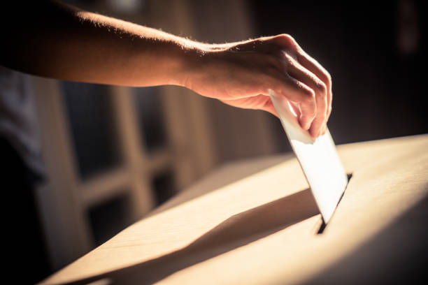 imagen conceptual de una persona que vota durante las elecciones - papeleta para votar fotografías e imágenes de stock